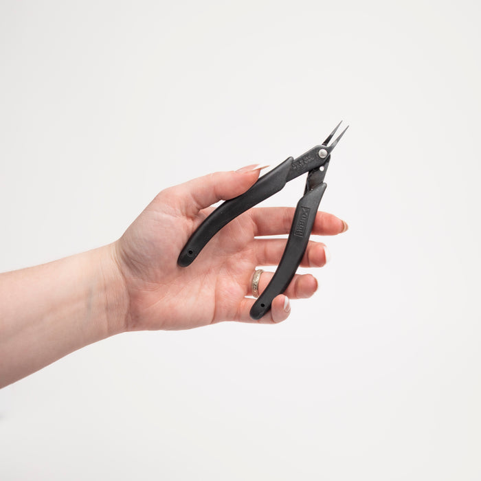 Hand holding a pair of black flat needle pliers against a white background