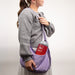 Person holding a purple bag with a small argon gas container labeled 'Ar' on a plain background